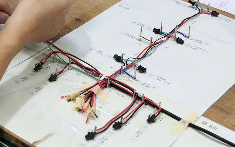 Wire harness assembly fixtures locating connectors and guiding branches on an assembly board